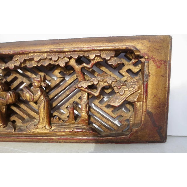 Chinese antique furniture panel scene of a court scene. Backed by a field of Chinese fretwork. A gilt finish over the...