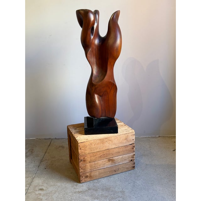 A mid century solid wood sculpture with an organic, figural freeform shape, carved from a single block. Finished in a warm...