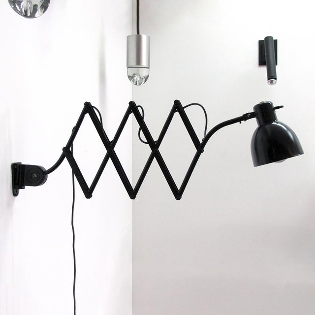 Articulating black enameled metal scissor wall lamp by Hala, extends from 19″ to 50″, hood with original aluminum interior