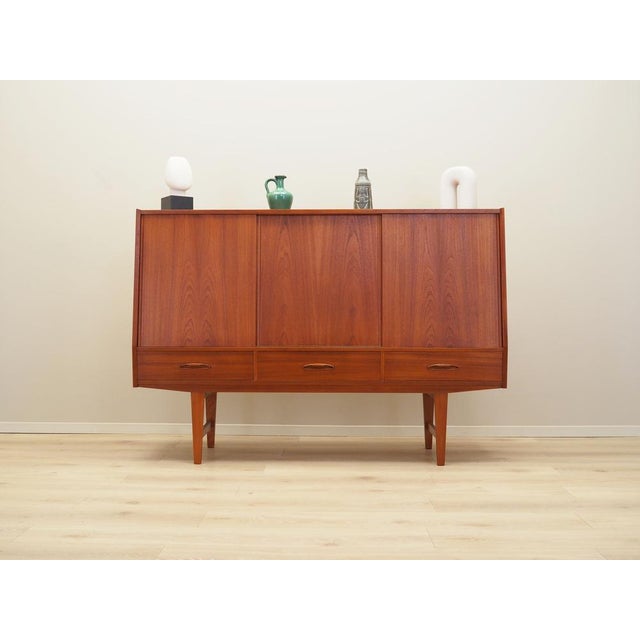 The highboard was made in the 1960s, Danish production. The structure is covered with teak veneer. The legs and handles...