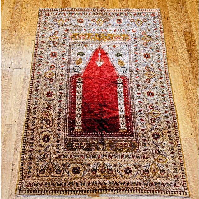 A magnificent late 19th-century Turkish all-silk prayer rug in the traditional Mihrab design, this exquisite textile...