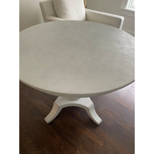 Round Swedish Neoclassical style painted round center/side table in pale gray with urn shaped pedestal base. Dimensions:...