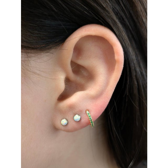 These real 14k yellow gold huggies showcase natural Zambian emeralds in a sleek, minimalist design. Lightweight and...