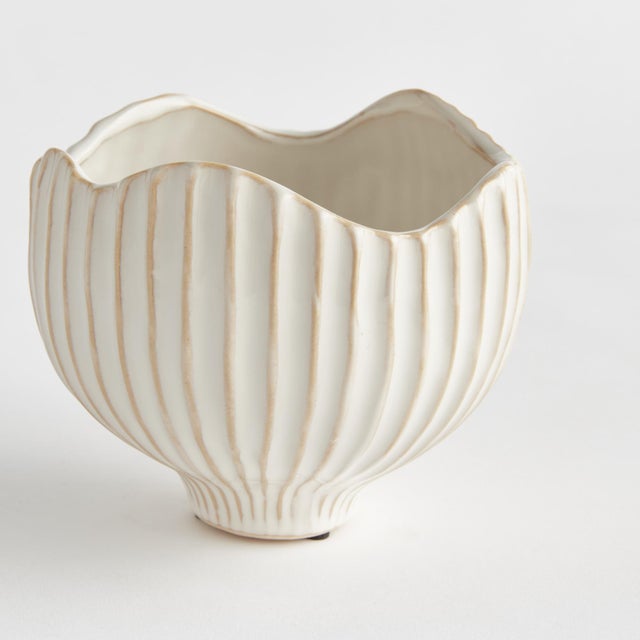 With a ribbed texture and wavy rim, this ceramic pot certainly brings the charm. Finished in a rich, reactive glaze, it...