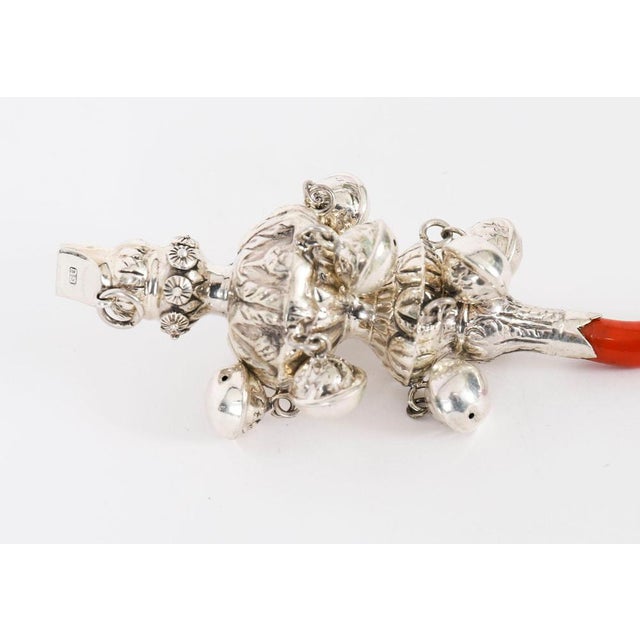 This vintage sterling silver baby rattle features a charming design with a faux coral handle, the mouthpiece is stamped...