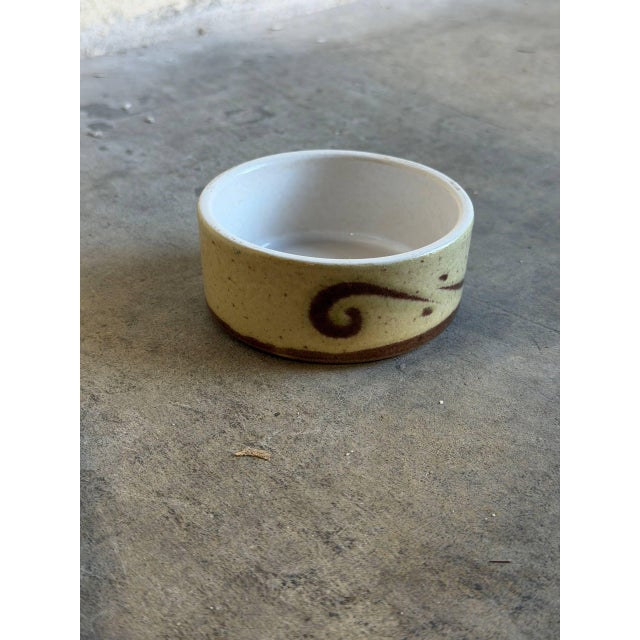 This charming studio pottery small bowl or ramekin features a speckled beige and pale yellow exterior accented by hand-...
