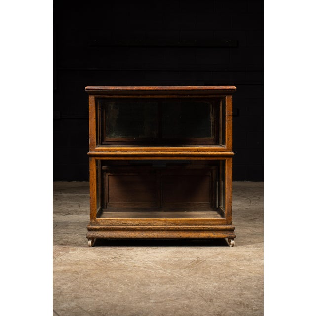 Oak mercantile display case on casters. This piece features mirrored doors on the top half of the case. Top and bottom...