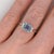 An aquamarine takes centre stage in a clear sea-blue at the centre of this solid 14K white gold ring, encircled by three...