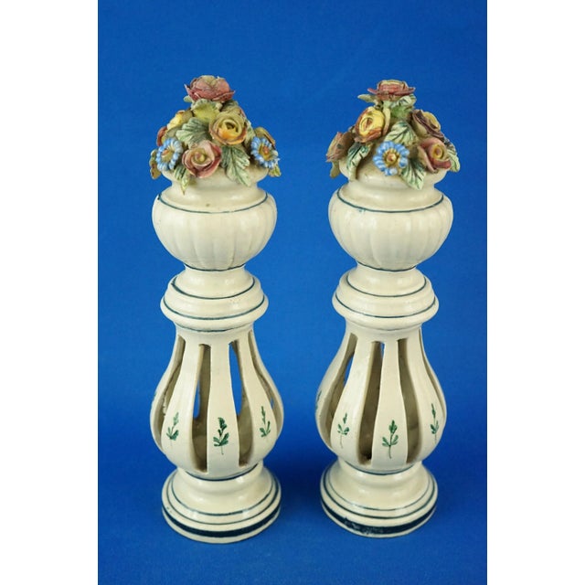 Item description: Pair of glazed and vitrified ceramic vases, entirely handmade and perforated, depicting two columns with...