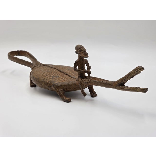 The Rare African Senufo Bronze Crocodile with Rider Ritual Oracle Figure is a unique and culturally significant piece from...