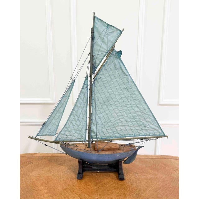 Made in England in the twentieth century, this model pond yacht takes the form of a gaff-rigged cutter, carved in wood and...