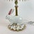 A whimsical and highly collectible MacKenzie-Childs table lamp featuring a sculptural porcelain rabbit base adorned with...