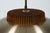 A sculptural Danish pendant from the 1970s, combining brushed aluminum, amber glass, and a concentric diffuser system...