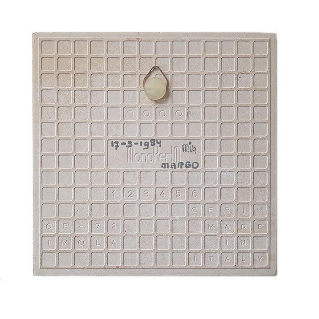 A ceramic tile featuring an illustration signed "Margo" and dated 1984. The illustration depicts four children with their...