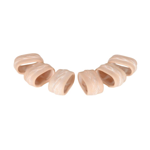 A set of six coastal style napkin rings. Unglazed ceramic in a soft coral color are pressed with a rope twist around the...
