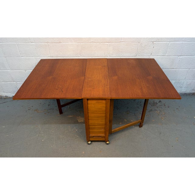 Add functional mid-century charm to your home with this Romanian Drop Leaf Hide-A-Way Table complete with four matching...
