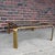 Mid-Century Modern brass and glass coffee table by Widdicomb, featuring a substantial brass frame with softly rounded...