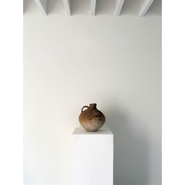 An antique Middle Eastern vessel formed by hand in earthenware, likely dating from the Bronze Age. This ancient and...