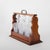An antique oak tantalus set featuring three finely crafted cut glass spirit decanters, dating to approximately C1920. This...
