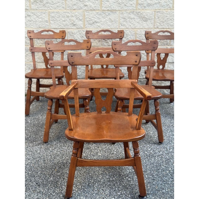 Cushman-style dining set, 7 pieces, mid 20th century. Solid wood construction with warm medium-tone finish. Dining table...