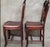 A beautifully crafted pair of Chinese hardwood side chairs, likely rosewood, featuring graceful horseshoe backs, hand-...