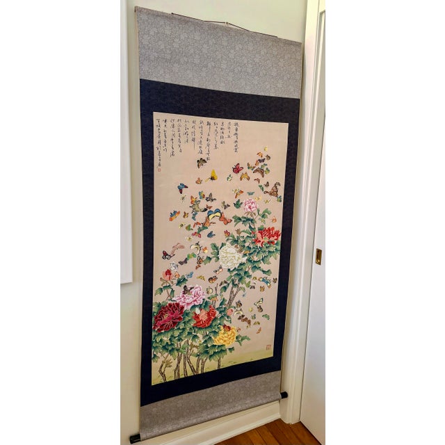 A stunning and highly decorative vintage Chinese hanging scroll painting depicting the classic “Hundred Butterflies” (Bǎi...