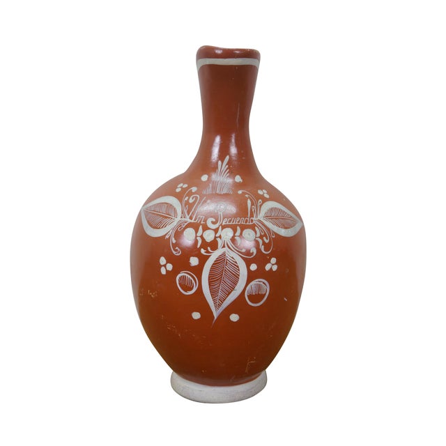 Vintage 20th century Mexican folk art style water pitcher. Made of earthenware ceramic with a rust red / orange glaze and...