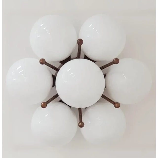 Italian flush mount with seven glossy white Murano glass globes mounted on solid brass frame in bronzed finish / Made in...
