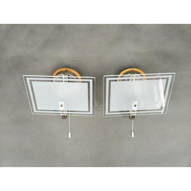 Elegant pair of art deco wall lights produced in czechoslovakia during the 1940s featuring frosted geometric glass panels,...