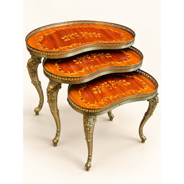 Exceptionally beautiful set of three interlocking side tables in an elegant kidney shape. The legs are richly decorated...