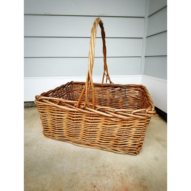 A beautifully oversized vintage handwoven willow gathering basket with an exceptionally large arched handle and...