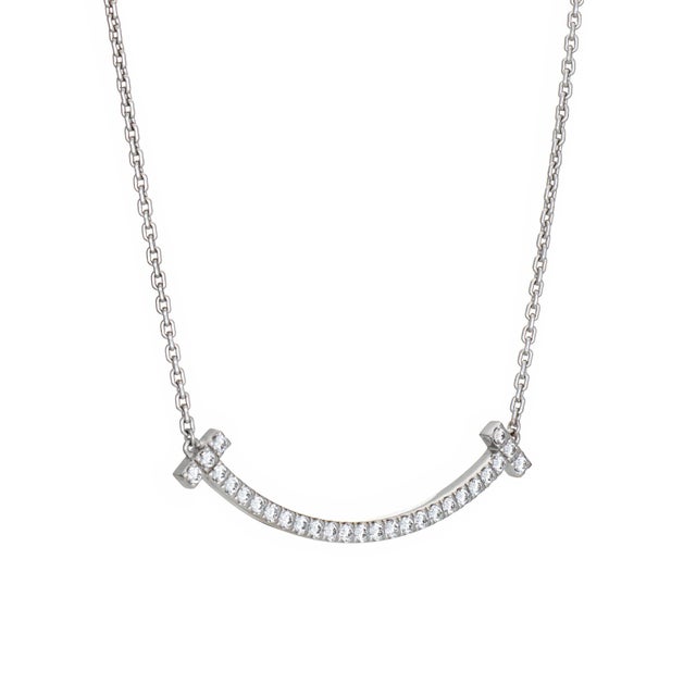 Stylish and finely detailed pre-owned Tiffany & Co T diamond "Smile" necklace crafted in 18k white gold. Diamonds total an...