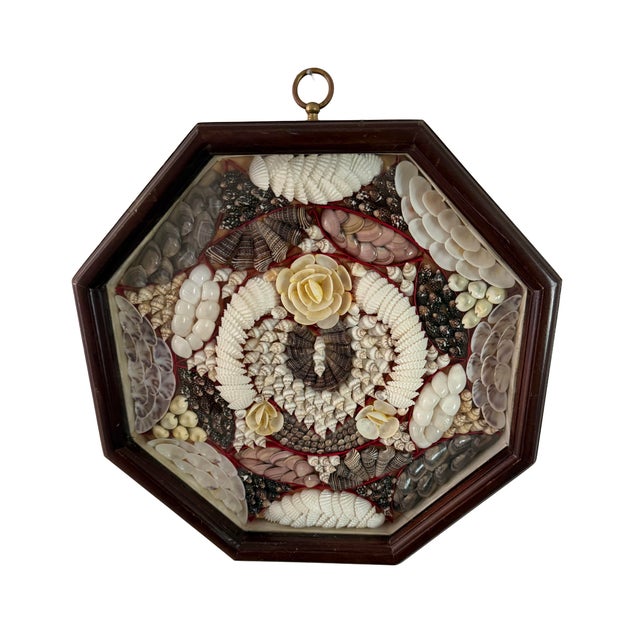 Vintage sailors' valentine handcrafted with seashells and arranged under glass in a mahogany octagonal shadow box.