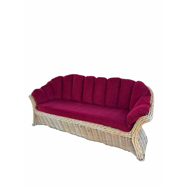 Dramatic vintage sculptural wicker sofa featuring oversized rattan frame and channel-tufted back cushions in rich...