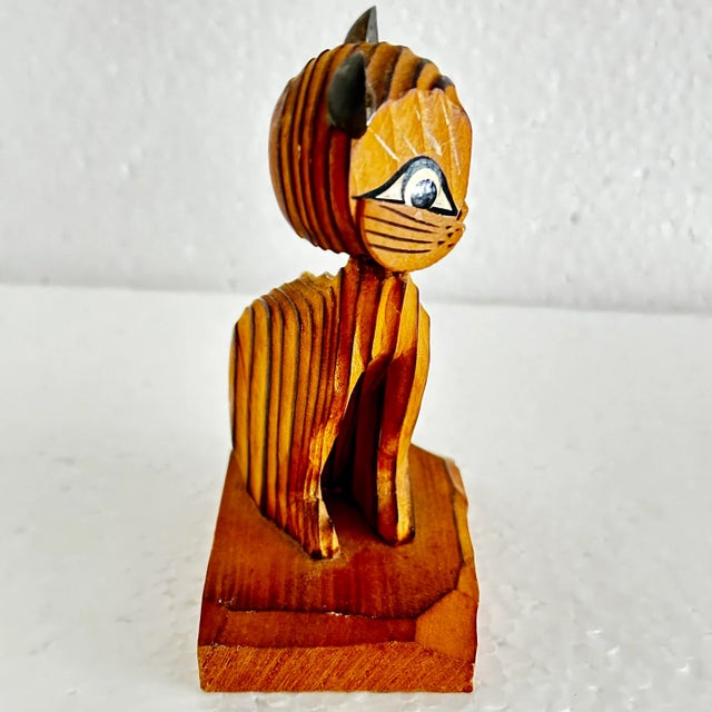 Cute carved wood sitting cat with spring loaded head. Yellow eyes. 3” x 2” x 4”.