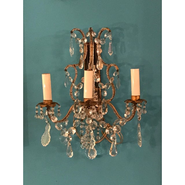 Exquisite pair of classic antique 19th-century European electrified wall sconces. They each have three gilded metal arms...