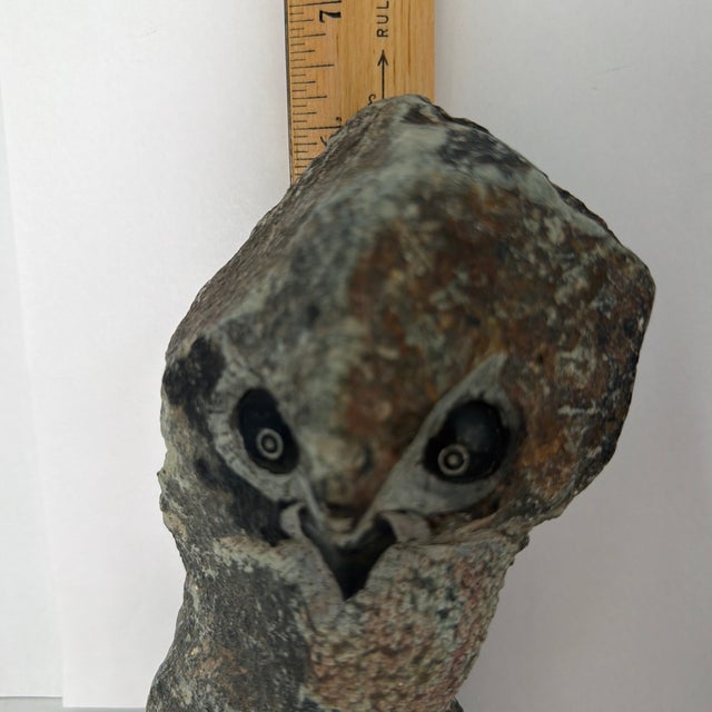 The object is a hand-carved stone owl sculpture created in the distinct tradition of Zimbabwean Shona art. It is crafted...