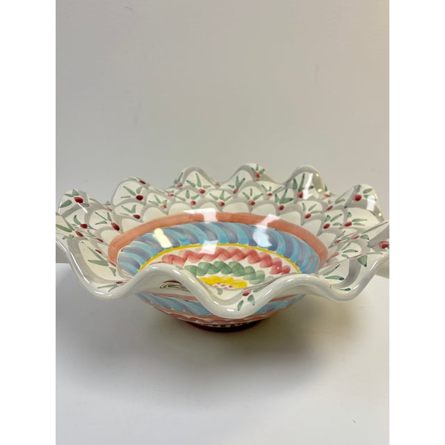 Charming fluted serving bowl from the whimsical house of Mackenzie Childs. Hand decorated in patterns of soft greens,...