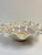 Charming fluted serving bowl from the whimsical house of Mackenzie Childs. Hand decorated in patterns of soft greens,...
