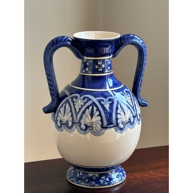 Add a touch of Mediterranean elegance to your home with this stunning amphora-inspired ceramic vase. Beautifully hand-...