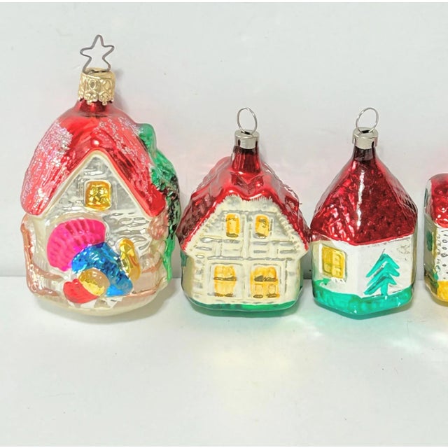A charming set of hand-painted European glass Christmas ornaments in the shape of colorful cottages. Each miniature house...