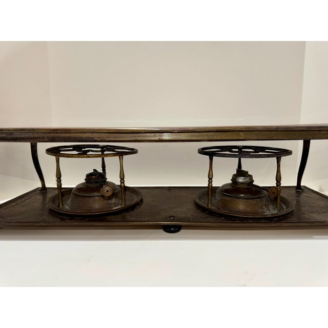 Elegant antique brass double burner warming stand dating to the late 19th or early 20th century. Features a hand-hammered...