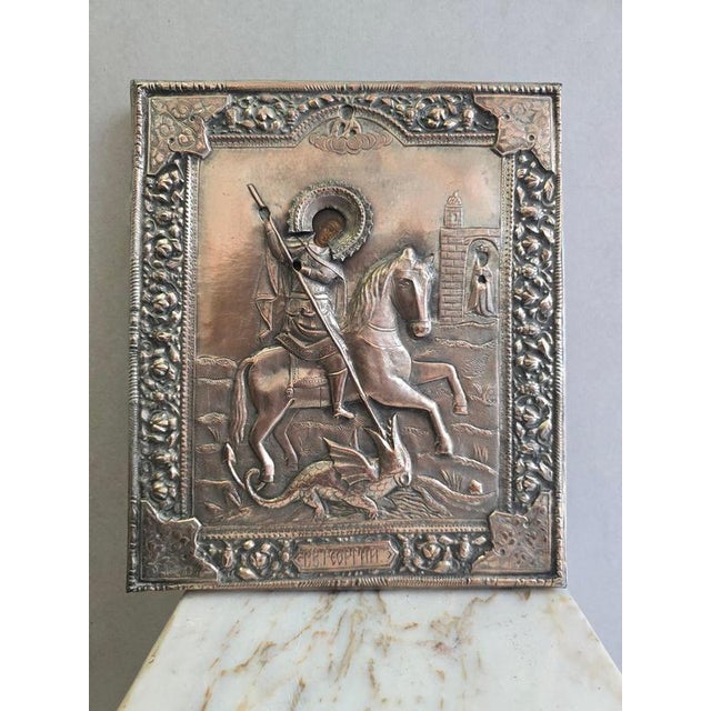 Exceptional religious icon depicting Saint George slaying the dragon, adorned with a finely worked repoussé and chased...