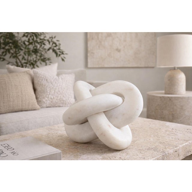 This sculptural marble knot features an elegant interlocking form with smooth, rounded contours and a timeless organic...