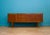 A stylish teak sideboard by Nathan Furniture, featuring three central drawers, twin cupboards and raised tapered legs. The...