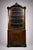 A mahogany corner bookcase from the napoleon iii period, of considerable height, topped with a richly carved pediment...