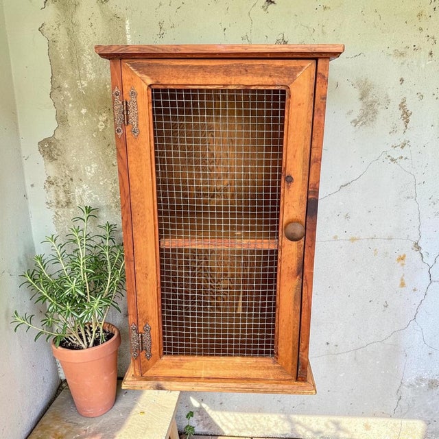 Mid century natural wood (no finish) knotty pine cabinet. One door with wire panel. Interior has two shelves. Measures...
