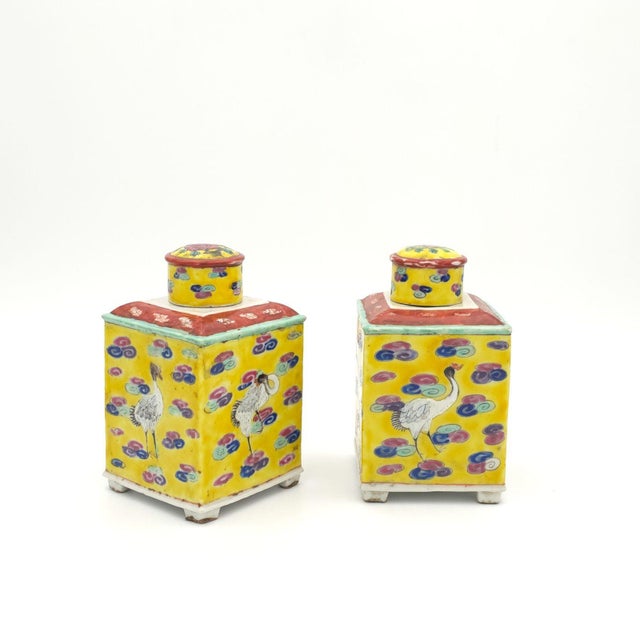 A pair of Chinese export tea caddies, probably Republic period, decorated with cranes and clouds on a yellow ground.