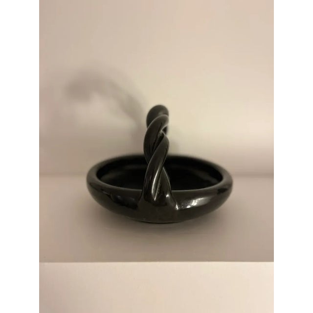 Bowl with twisted handle. Black glazed ceramic, signed Accolay on the base. 14 x 20 cm. In the style of Georges Jouve, Pol...