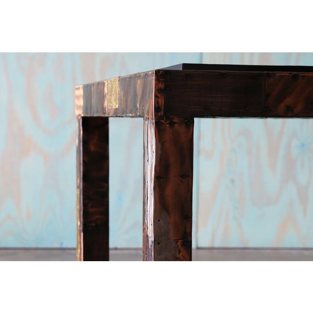 A 1960s mixed metal table with thick inset chiseled slate top. Signature Paul Evans style. . The bottom of the slate hand...